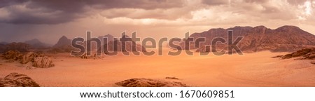 Wadi Rum desert in Jordan under dramtic rain and storm clouds. Panorama picture. 
