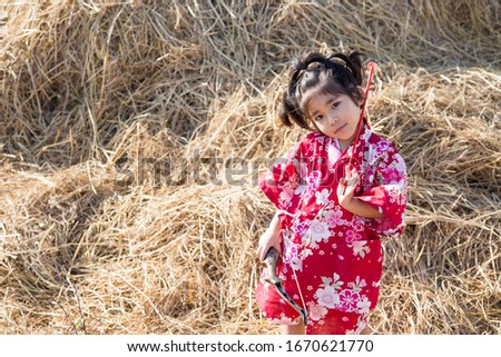 asian kid playing arrow sport on straw with Japanese suite