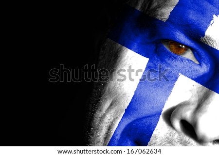 An adult sports fan with his face painted in the colors of Finland's flag