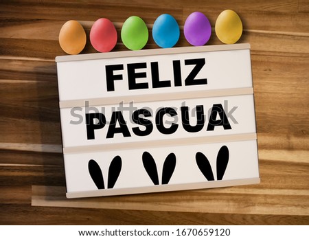 Lightbox or light box with easter eggs and spanish words for happy easter - feliz pascua on a wooden background