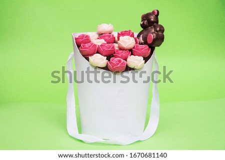 white and red roses. Roses in a white basket on a green background