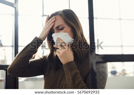 Woman having a fever from corona virus covid-19 while wearing a protective face mask
