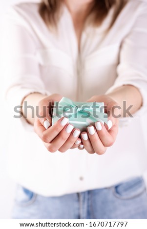 human hands holding a gift. Holiday concept on a light background
