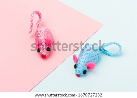 two blue and pink toy mice for a pet cat isolated on a blue and pink background, close-up
