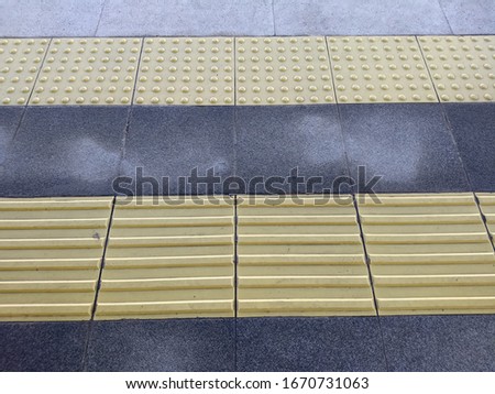 Yellow tactile floor signs for blind person in the station, detectable warning surface for blind person safety