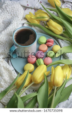 Beautiful morning cup of coffee and colorful flowers on a wooden background. Flat style. Creative breakfast for women's day.
