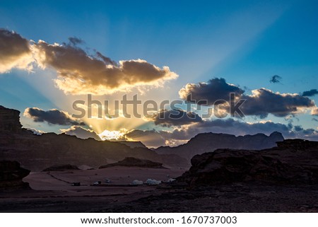 Kingdom of Jordan, Wadi Rum desert, impressive sunset sky and light over desert in darkness and shadows. Lovely travel photography. Beautiful desert could be explored on safari. Colorful image