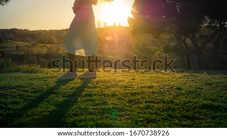 Beautiful young pregnant woman living a healthy lifestyle outdoors and enjoying warm weather in the green park in Madrid, Spain