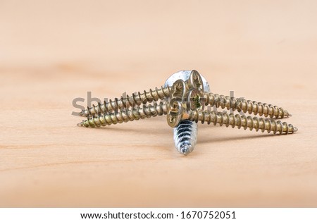 Metal screws on a wooden background. Close up. Copy space.