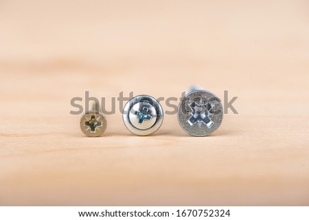 Slots of metal screws. Metal screws on a wooden background. Copy space. Close up