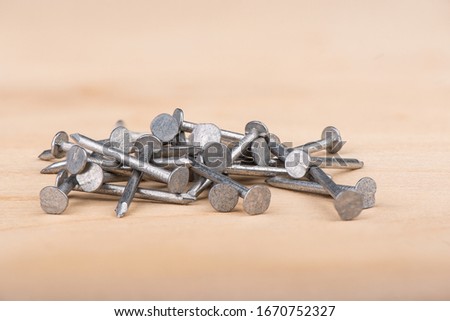 Metal nails on a wooden background. Copy space. Close up.