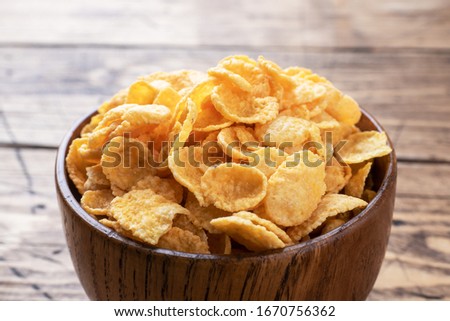 Dry flakes of corn and natural cereals for Breakfast with milk. Wooden background. Copy space
