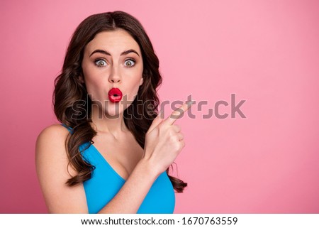 Closeup photo of pretty wavy lady open mouth direct finger empty space showing cool low prices advert banner wear casual blue singlet isolated pink pastel color background