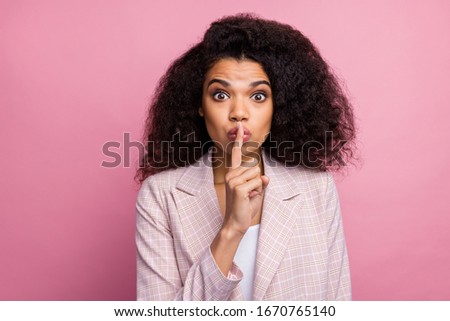 Hush private novelty. Astonished marketer afro american girl put index finger lips dont tell managers company speechless secrets wear plaid stylish jacket suit isolated pastel pink color background