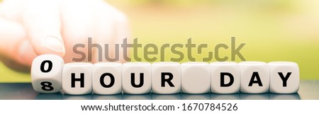 Hand turns dice and changes the expression "8 hour day" to "0 hour day". Royalty-Free Stock Photo #1670784526
