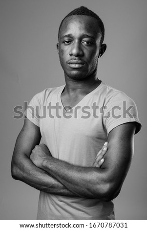 Portrait of young African man against gray background