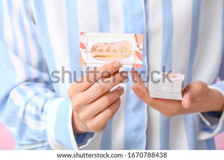 Woman with business cards of makeup artist, closeup