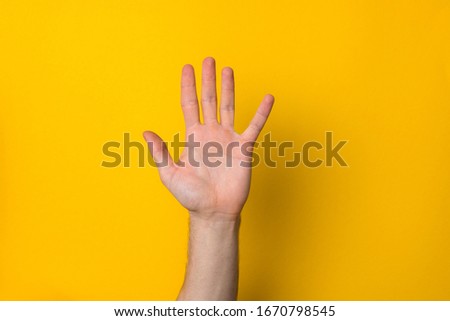 man hand up over a yellow background with copyspace for advert banner