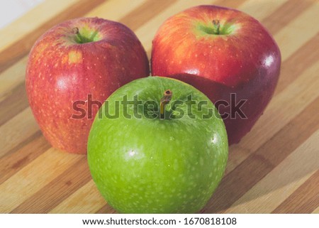 juicy green and red apples on a wooden table
