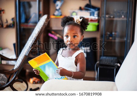 little cute african american girl playing with animal toys at home, pretty adorable princess in interior happy smiling, lifestyle people concept