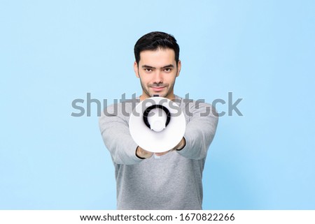 Young handsome man with megaphone isolated on light blue background