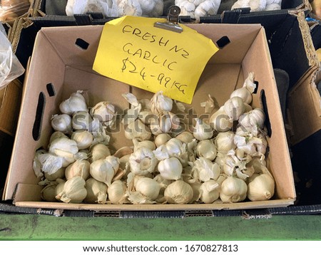The garlic spreading in a paper tray with a yellow sign.