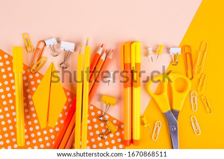 School supplies on orange background. Top view. Copy space.