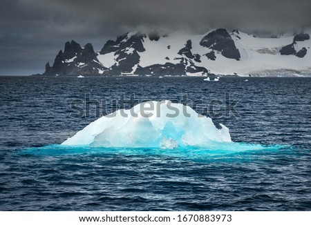 little iceberg in water with blue shining in Antarctica