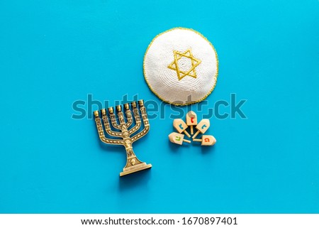 Jewish Kippah Yarmulkes hats with Star of David with menorah. Religion Judaisim symbols on blue table. Top view, space for text
