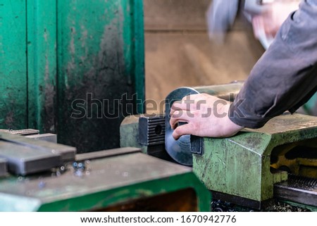 The worker sets the metal workpiece in a vice for processing on a CNC milling machine.