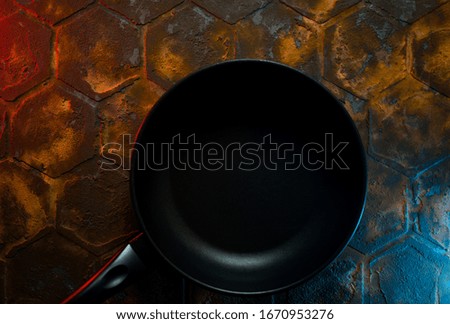 black grill pan with empty place for dish menu isolated on colorful stylish metallic background