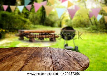 Wooden table of free space for your decoration and blurred background of park and spring time.Grill time and party. 