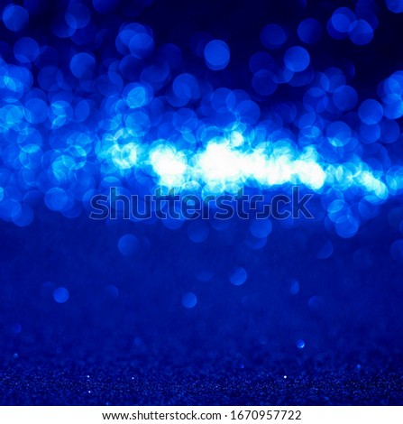 blue Sparkling Lights Festive background with texture. Abstract Christmas twinkled bright bokeh defocused and Falling stars. Winter Card or invitation.