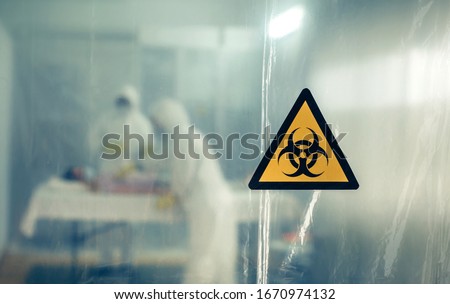 Unrecognizable doctors with bacteriological protection suits attending a patient infected with a virus Royalty-Free Stock Photo #1670974132