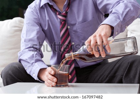 An elegant man suffering from alcoholism drinking whisky Royalty-Free Stock Photo #167097482