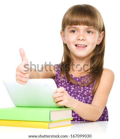 Little girl is using tablet and showing thumb up sign