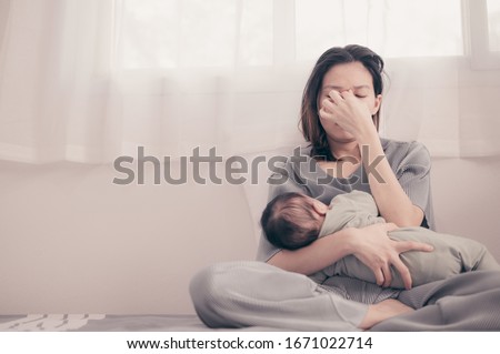 Tired Mother Suffering from experiencing postnatal depression.Health care single mom motherhood stressful. Royalty-Free Stock Photo #1671022714