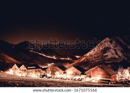 Snowy mountain with villag...to the dark with stars