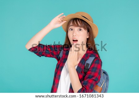 Beautiful portrait young asian woman smiling and surprise wearing travel summer fashion tourist in vacation isolated on blue background, girl shocked expression and emotion, holiday concept.
