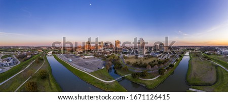 Aerial panorama picture of the Fort Worth skyline at sunset from west direction with sun reflections