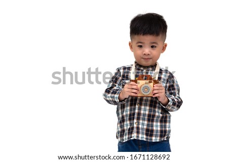 Attractive Asian little boy photographer wearing striped shirt standing isolated over white background, Taking a picture with toy photo camera, Two year one month old