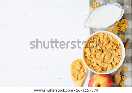 Corn flakes, milk, and an Apple on the tablecloth. Healthy and nutritious Breakfast. White background. Copy space