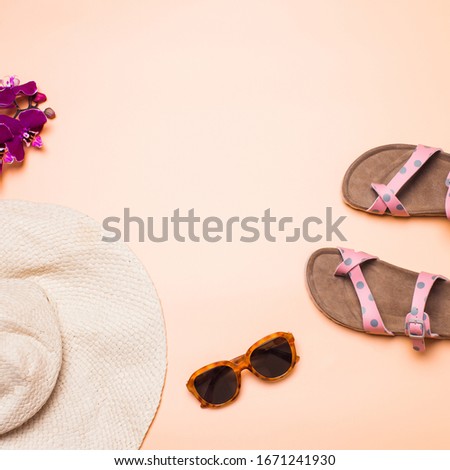 Straw hat, sandals and sunglasses on a pink background, square