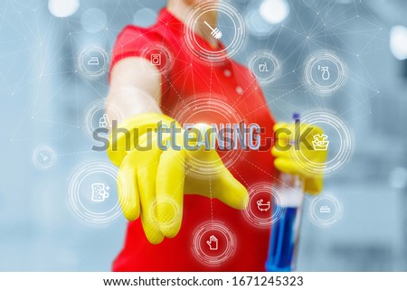 Cleaning concept. A cleaning lady clicks on the word cleaning on a blurred background.