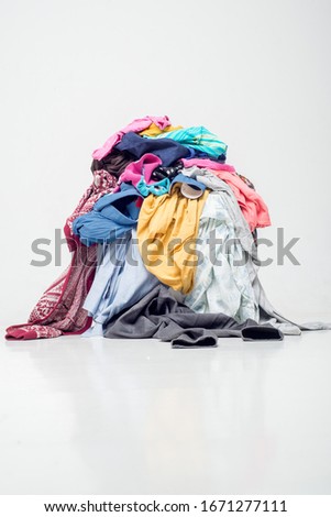 pile of used clothes on a light background. Second hand for recycling Royalty-Free Stock Photo #1671277111