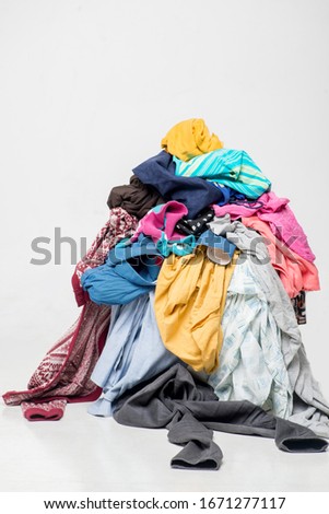 pile of used clothes on a light background. Second hand for recycling Royalty-Free Stock Photo #1671277117