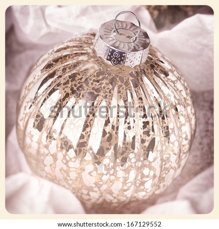 Antique glass Christmas tree bauble wrapped in protective tissue. Cross-processed to look like an aged instant photo.