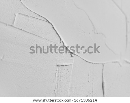 Large strokes of white plaster on the wall. Traces of a spatula. Wallpaper. Background