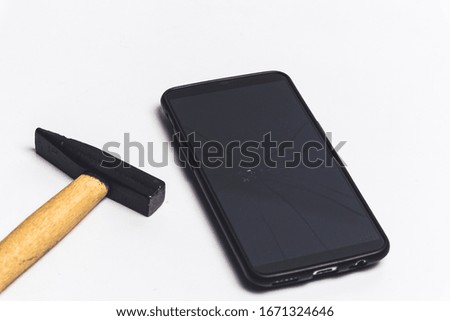 a hammer and a broken phone glass over white background - stop addiction to phone concept
