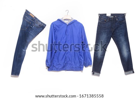 fashion. Closeup of blue windbreaker jeans shirts on hanging and blue two jeans on hanging 

